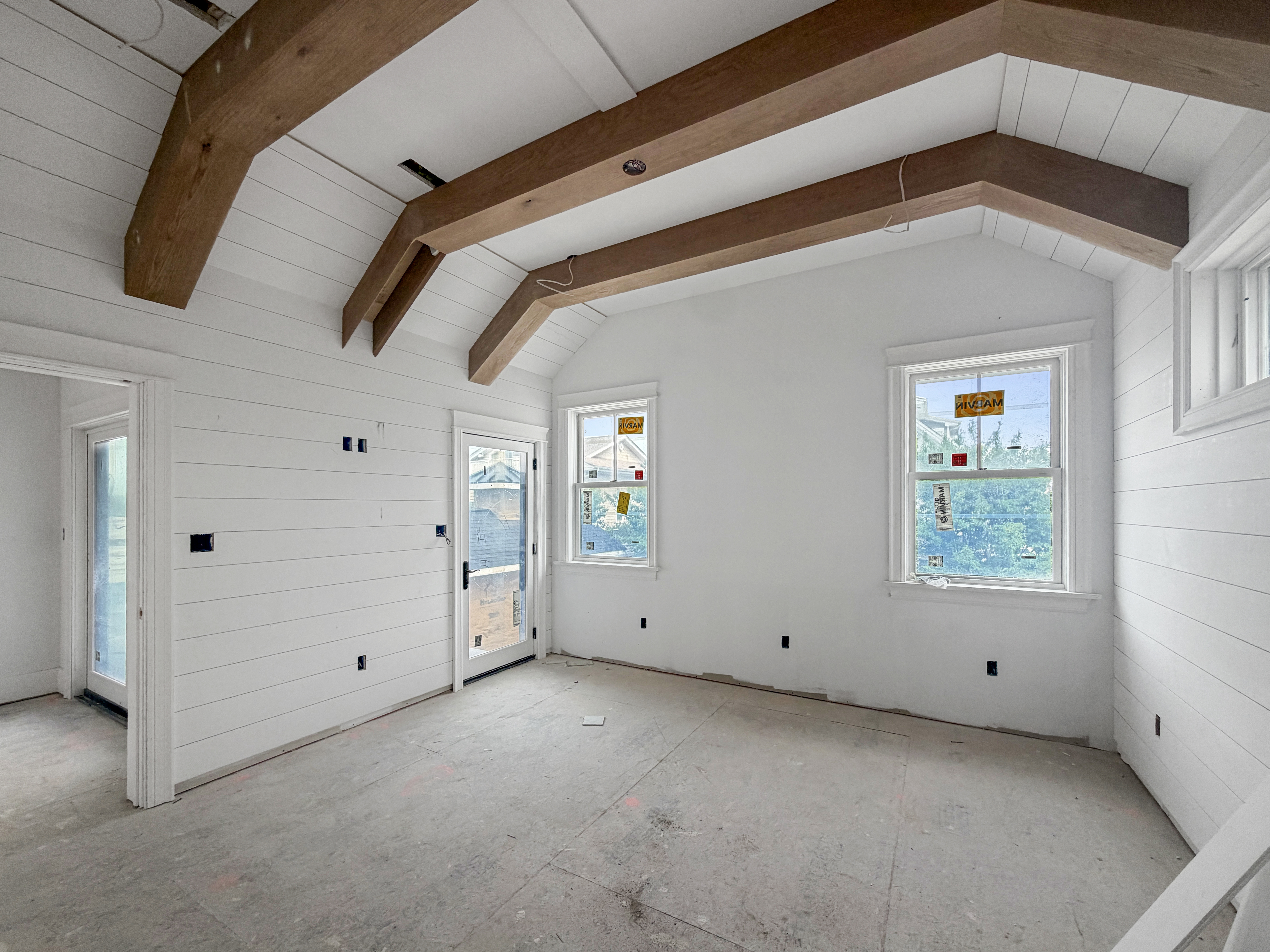 Interior progress at 905 Seacrest Rd, June 2026 — vaulted ceiling with exposed beams