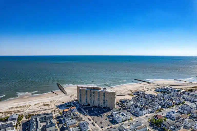 Aerial of the Ocean City NJ beach and ocean beside Gardens Plaza