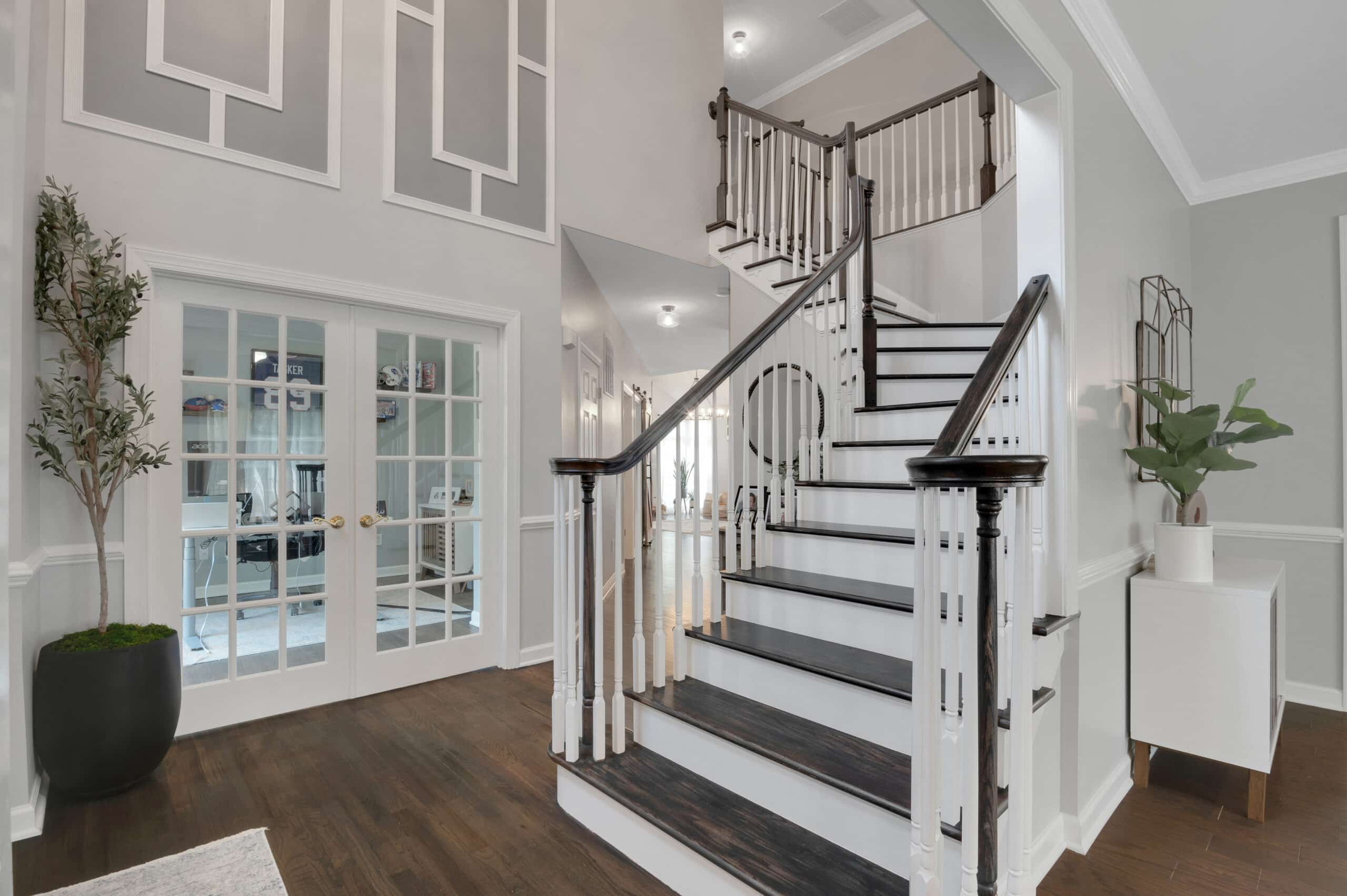 Professional real estate listing photograph of a two story foyer and staircase